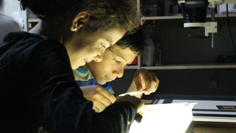 Juan and a friend developing photos in the darkroom. 