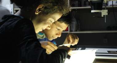 Juan and a friend developing photos in the darkroom. 