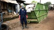 2019-abfall-management-sierra-leone-container_C_Kai-Loeffelbein-16-9.jpg Waste management worker in work clothes and mouthguard.
