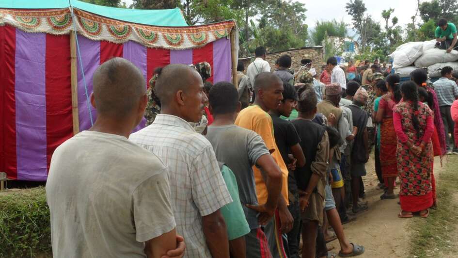 Men with shaved heads are standing in line