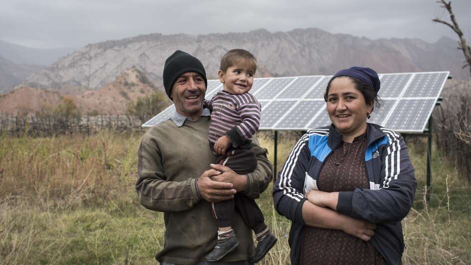 Eine Familie vor ihrer Solaranlage in Tadschikistan.