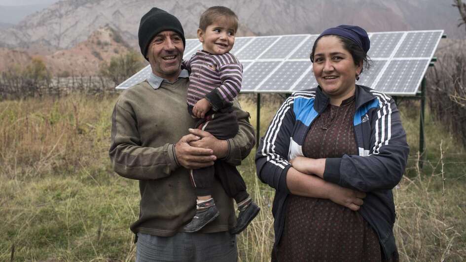 Eine Familie vor ihrer Solaranlage in Tadschikistan.
