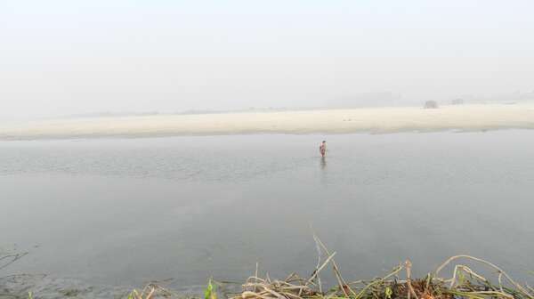 Ein Kind überquert einen Fluss, auf seinem Weg zur Schule.