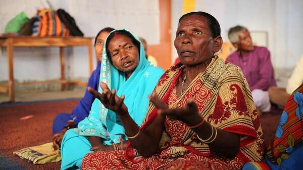 Ältere Frauen sitzen auf dem Boden und reden 