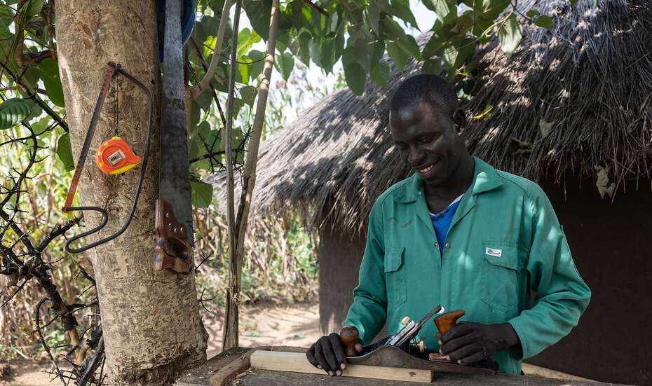 Ein Schreiner bearbeitet ein Stück Holz