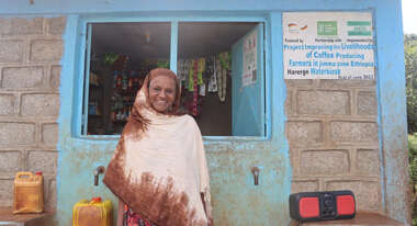 A woman in Ethiopia standing in front of a water kiosk where she can buy clean water