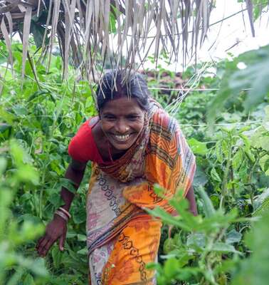 A woman is scrambling through a jungle.
