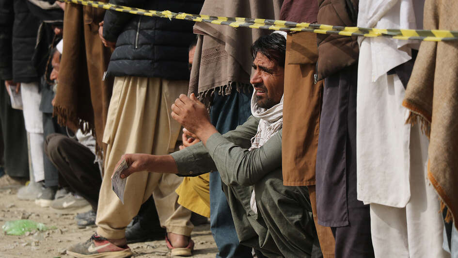 Männer warten auf den Beginn der Lebensmittelverteilung, Afghanistan 2022. 